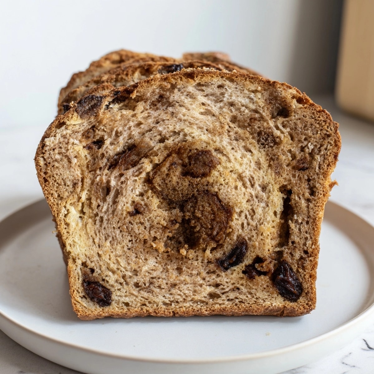 Slices of Protein Cinnamon Raisin Bread, toasted and spread with almond butter.
