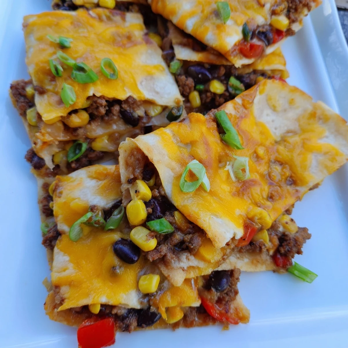 Golden brown sheet pan quesadillas with seasoned beef and melted cheese, perfect for dinner.