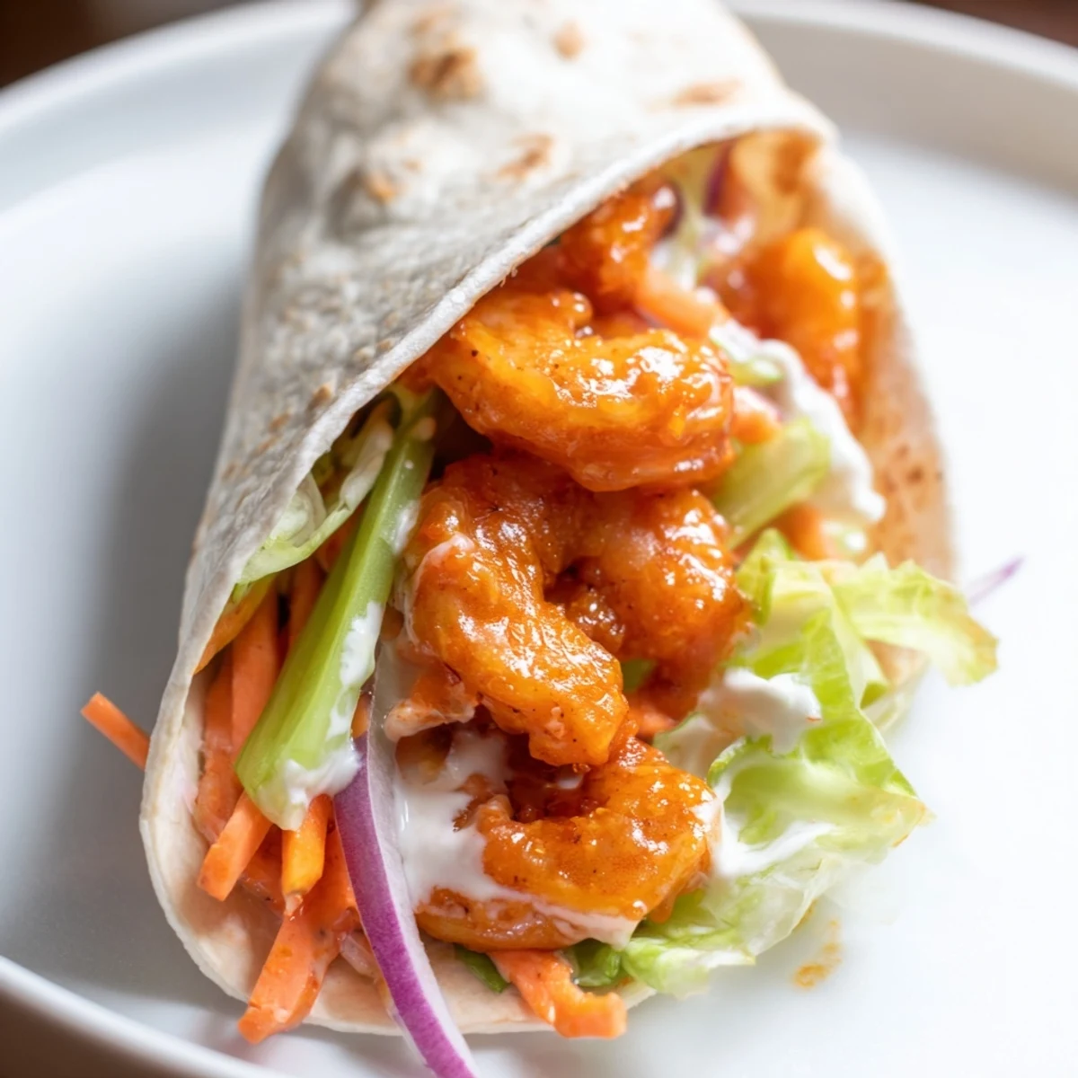 Enjoy a delicious Buffalo Shrimp Wrap, boasting flavors of tangy buffalo sauce and cool, crisp veggies.