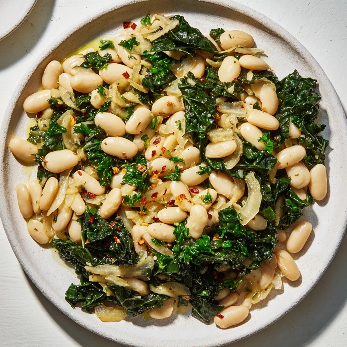 Tender kale and creamy cannellini beans make this Garlicky Beans with Winter Greens recipe delicious.