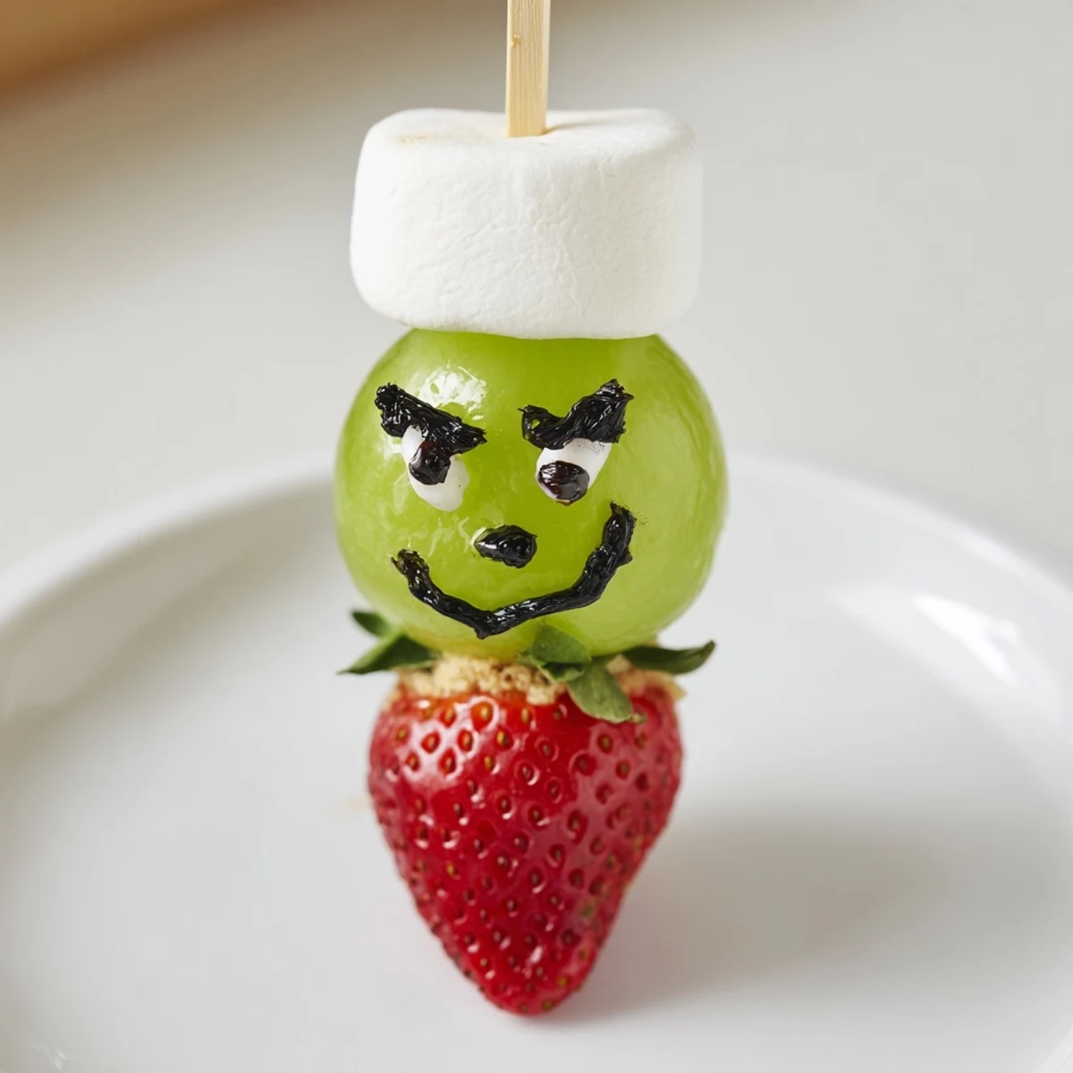 Grinch Snack: a fun arrangement of green grapes, marshmallows, and strawberry "hats" for kids' snacks.