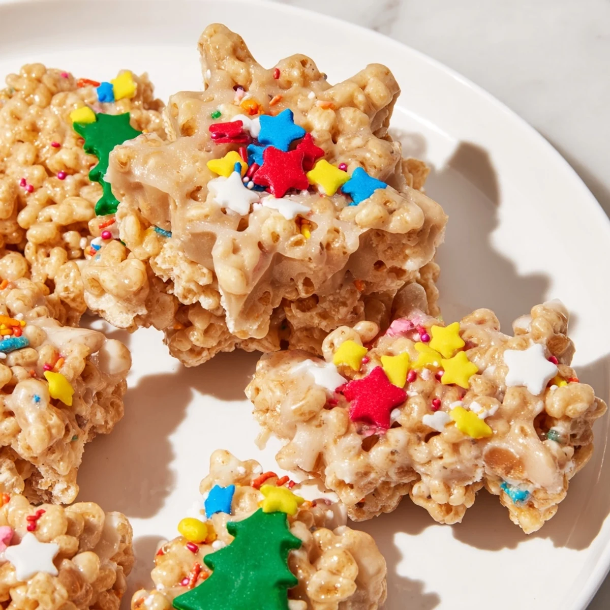 Sweet cookie cutter-shaped Rice Krispies treats topped with colorful sprinkles for a fun snack.