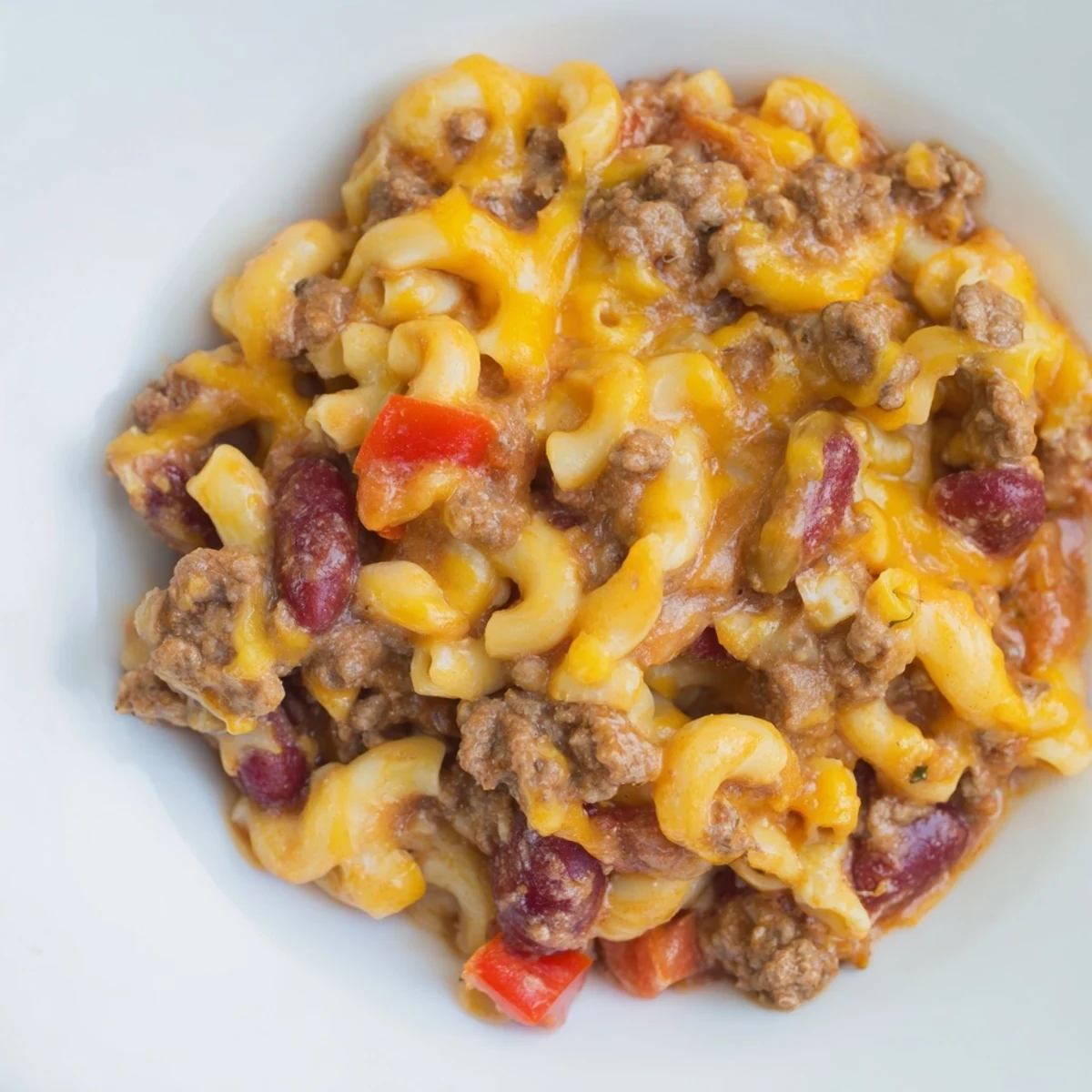 Steaming bowl of One-Pot Chili Mac, a hearty main dish with melted cheese and rich sauce.