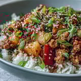 Stir-fried Sweet-and-Sour Turkey Rice Skillet served in a skillet, garnished with green onions and sesame seeds for dinner.