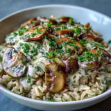 A generous serving of Vegan Mushroom Stroganoff over brown rice, topped with fresh parsley and a bright squeeze of lemon juice.