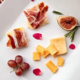 Artfully arranged Crimson Crest charcuterie ingredients, including cured meats, red wine-soaked cheeses, and grapes.
