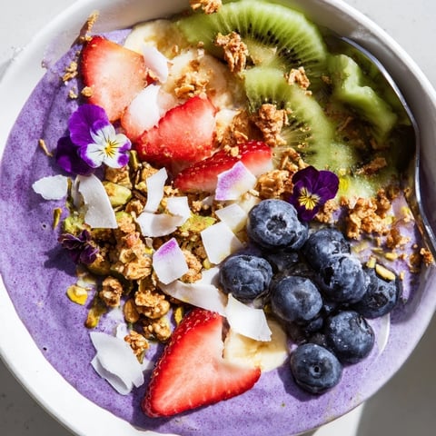 Vibrant smoothie bowls feature creamy purple yam and colorful fresh fruit toppings.  