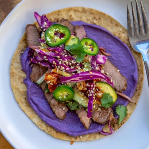 Vibrant Global Street-Food Fusion Tacos garnished with fresh toppings and creamy ube crema.  