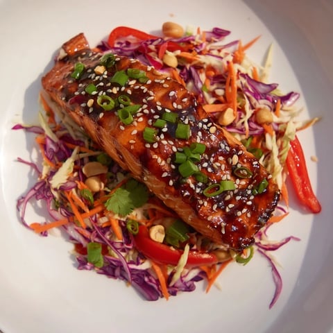 Tender teriyaki salmon glistens atop a crunchy Asian slaw in this enticing bowl.