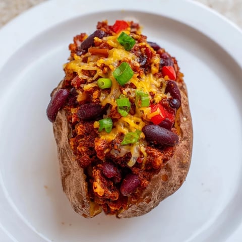 Steaming Chili-Style Baked Potatoes, loaded with a rich and hearty bean chili, ready to eat.