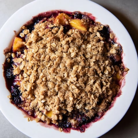 Warm fruit crisp bubbling with mixed berries; this easy dessert has an oat topping.