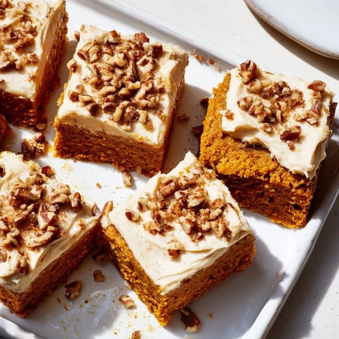 Warm, spiced pumpkin bars with creamy brown sugar frosting, a delicious fall dessert.