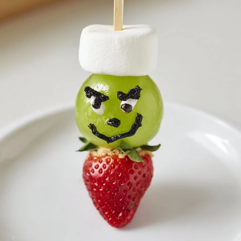 Grinch Snack: a fun arrangement of green grapes, marshmallows, and strawberry "hats" for kids' snacks.
