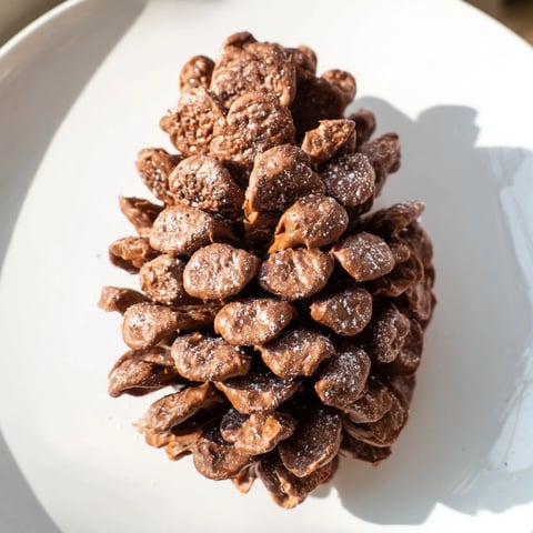Festive Pinecone Nut Butter Snacks, coated in cereal, ready for enjoying during the holidays.