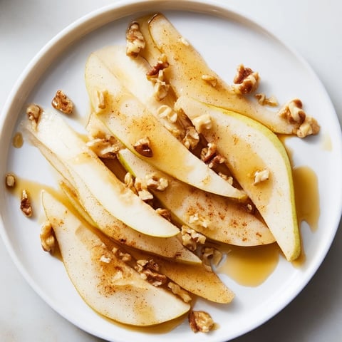 Fresh pear slices with golden honey drizzle, a simple way to enjoy this delicious snack.