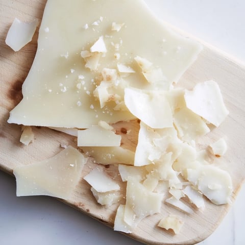 White chocolate "Arctic Tundra" dessert with salty parmesan shards on a wooden board ready to serve.