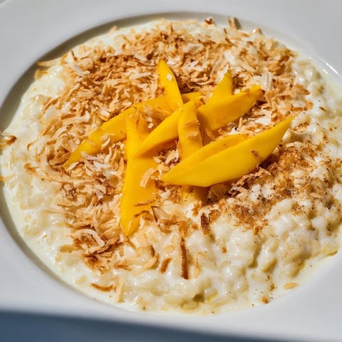 Golden toasted coconut flakes topping a bowl of creamy Toasted Coconut Rice Pudding.