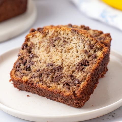 Warm, golden banana bread with visible chocolate chips, perfect for a cozy afternoon treat.