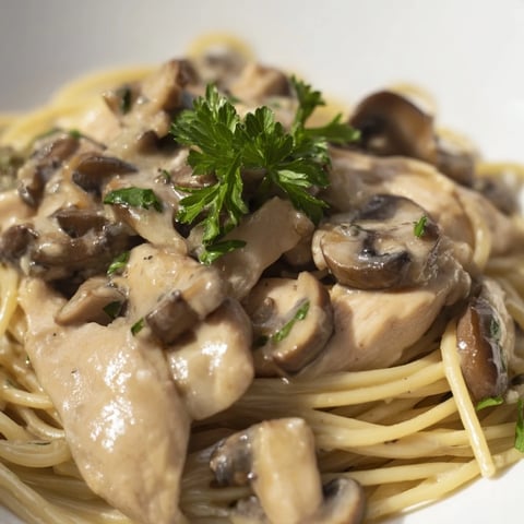 Creamy Mushroom Chicken Spaghettini features tender chicken strips and al dente pasta coated in a velvety, light mushroom cream sauce garnished with fresh parsley.  