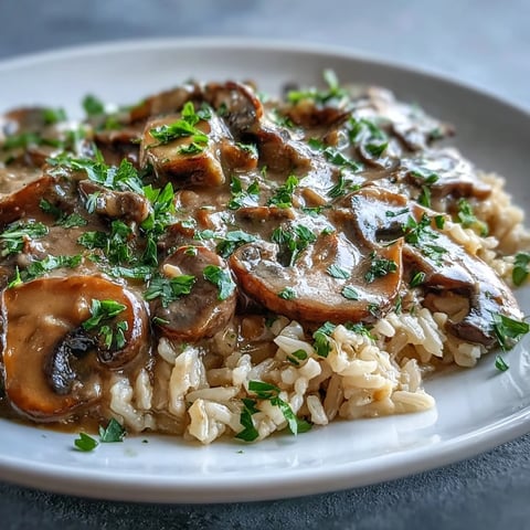 Freshly sautéed mushrooms and onions simmer in a creamy, savory Vegan Mushroom Stroganoff sauce, ready to spoon over fluffy brown rice.