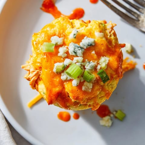 Cheesy muffins bursting with bold buffalo chicken flavors, ideal for game day snacking.  