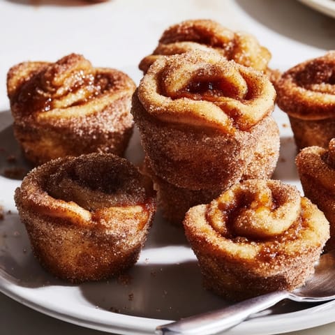 Mini muffin bites filled with apple butter, offering a warm, cinnamon-coated treat.  