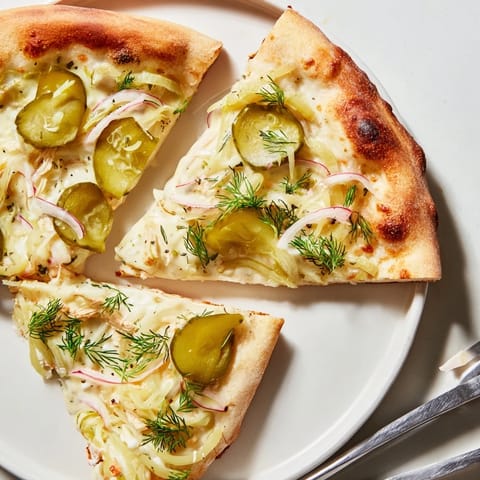 Sizzling homemade pickle pizza drizzled with crème fraîche and vibrant fresh dill.  