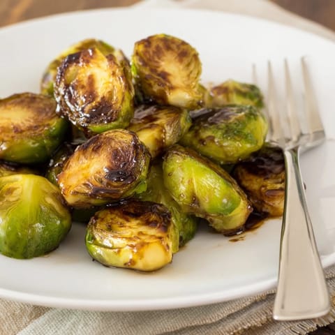 Roasted Brussels sprouts with balsamic reduction, caramelized edges adding a sweet-tart flavor perfect for modern American dinners.