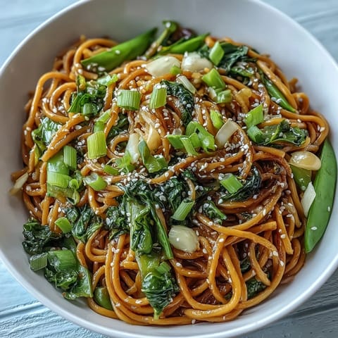 Silky noodles coated in fragrant ginger-scallion oil, served with vibrant sautéed bok choy and snap peas.  