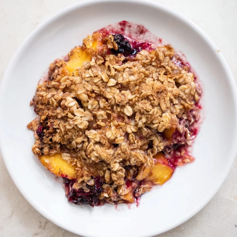 Golden-brown fruit crisp with frozen fruit, cinnamon, and a buttery oat crumble, ready to serve warm.