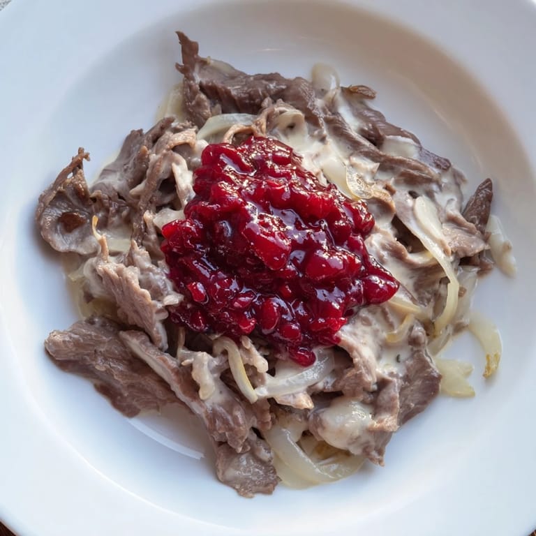 Slow-cooked Finnish Reindeer Stew, a rustic Nordic delight, garnished ready to serve with a dollop of sour cream.