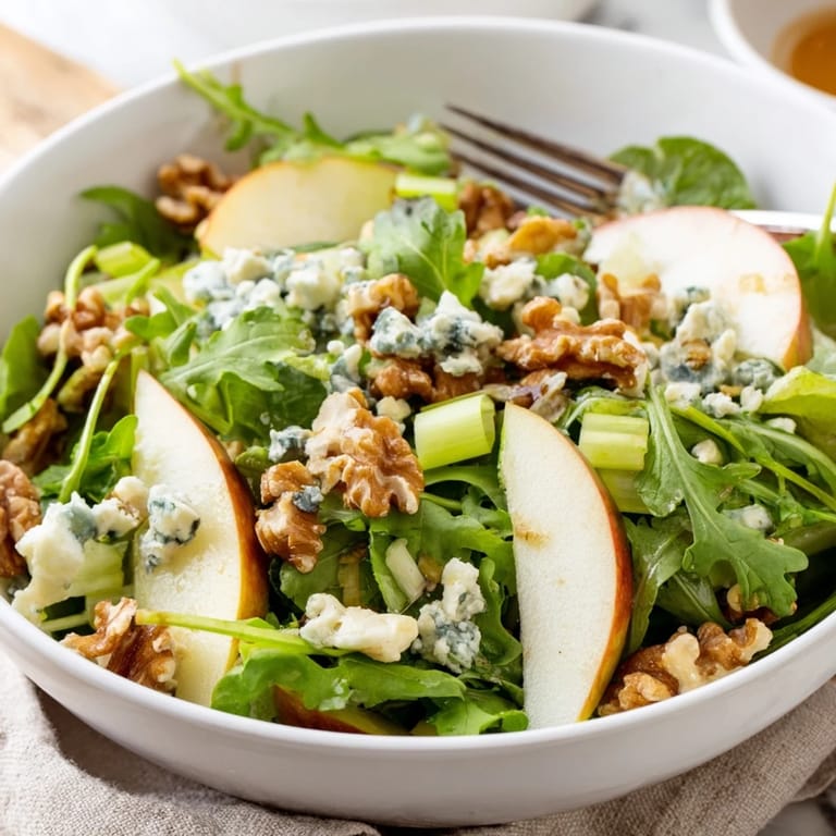 A vibrant Apple and Walnut Salad in a white bowl, drizzled with dressing and ready to serve as a refreshing side.