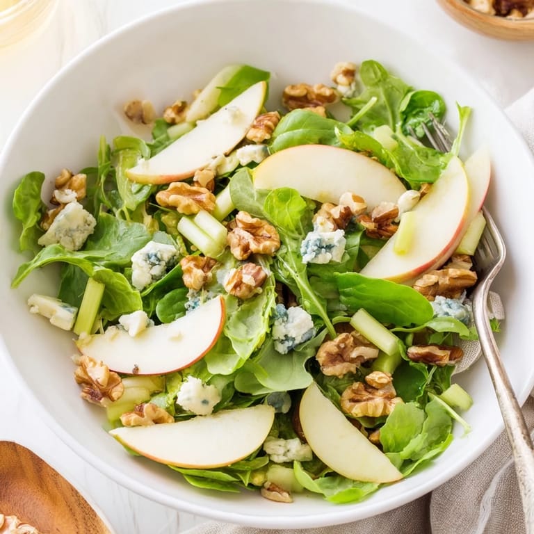 Close-up of a crisp Apple and Walnut Salad featuring celery slices, greens, walnuts, and cheese, highlighting fresh textures.