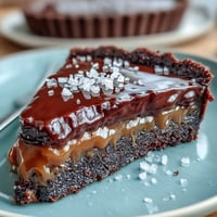 Decadent salted caramel chocolate tart with rich dark ganache and flaky sea salt topping.