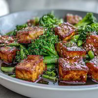 Vibrant teriyaki tofu stir-fry with crispy tofu, broccoli, and snap peas in savory sauce, perfect for a healthy vegan dinner.