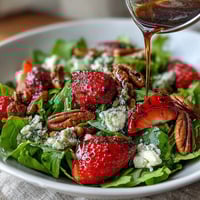 Spring Dinner Party Strawberry Arugula Salad with Balsamic Glaze, showcasing vibrant strawberries, peppery arugula, creamy goat cheese, and toasted nuts.